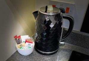 a black coffee pot sitting on a counter with a bowl at Cambridge Apartment with free onsite parking in Cambridge