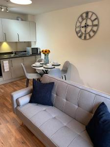 a living room with a couch and a clock on the wall at Cambridge Apartment with free onsite parking in Cambridge