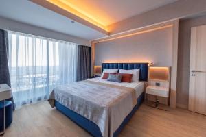 a bedroom with a large bed and a large window at Lago Hotel in Side