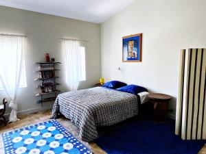 1 dormitorio con cama y alfombra azul en La Paloma La Palme, en Lapalme