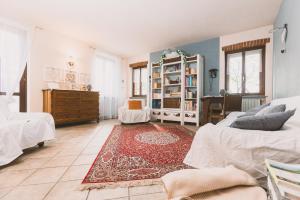 uma sala de estar com duas camas e um tapete em Lanterna delle Fate House and swimming pool for exclusive use em Asti