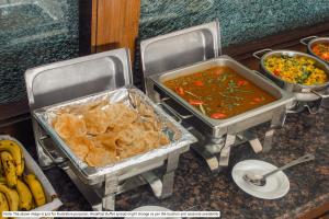 two trays of food sitting on a counter with food at Treebo Trend The Appa'S Resort in Mahabaleshwar
