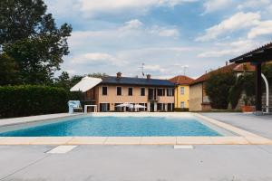 a large swimming pool in front of a house at B&B Lanterna delle Fate in Asti