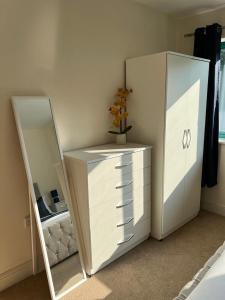 a white dresser and mirror in a room at Cambridge Apartment with free onsite parking in Cambridge