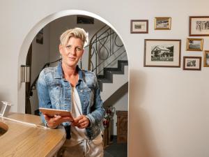 a woman standing in a room with a tablet at Pension Haus in der Sonne in Fieberbrunn