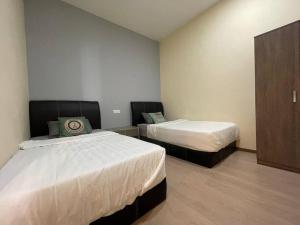 une chambre d'hôtel avec deux lits et une armoire dans l'établissement 仙本那镇上民宿-夏之家 Semporna Town Homestay-Summer Home, à Semporna