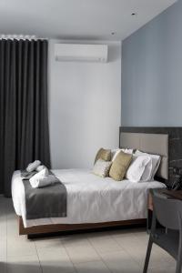 Un dormitorio con una cama con sábanas y almohadas blancas. en Marea Central Apartments, en Sliema
