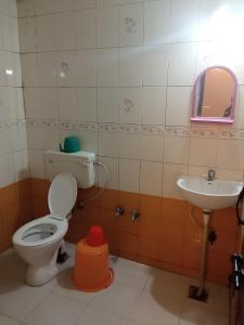 a bathroom with a toilet and a sink at SRI VIJAYA PALACE LODGING in Bangalore