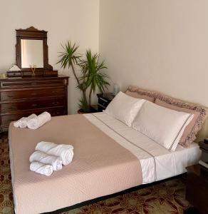 ein Schlafzimmer mit einem Bett mit zwei gefalteten Handtüchern darauf in der Unterkunft Filippo Secondo in Neapel