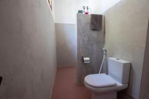 a bathroom with a white toilet in a room at The Wishing Tree in Pingwe