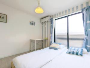 1 dormitorio con 2 camas y ventana grande en japan house itabashi, en Tokio