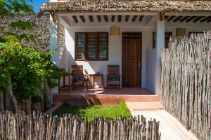 a wooden fence in front of a small house at The Wishing Tree in Pingwe
