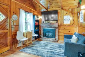 a living room with a fireplace and wooden walls at Twain Harte Cabin with Deck and Fire Pit! in Twain Harte
