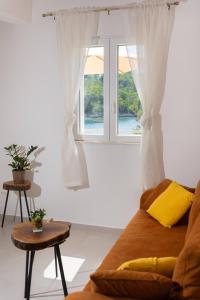 a living room with a couch and a window at Apartments Laurea in Slano