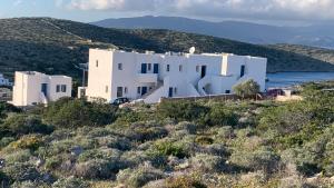 a white house on the side of a hill at COSMOS Studios Iraklia in Áyios Yeóryios