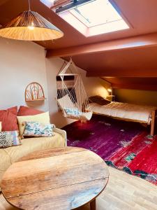 a room with a couch and a table and swings at Maison de plage à 100m de la mer in Talmont