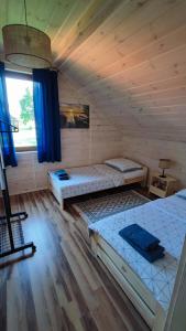 a room with two beds in a log cabin at Nad Kalwą in Pasym