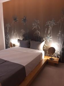 a bedroom with a large bed with plants on the wall at Sroom Apartment in Missolonghi
