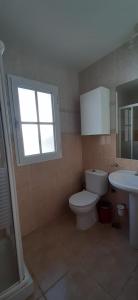 a bathroom with a toilet and a sink and a window at Villa Maracay-Caleta de Fuste-fiber optic 600mb in Caleta De Fuste +13 photos