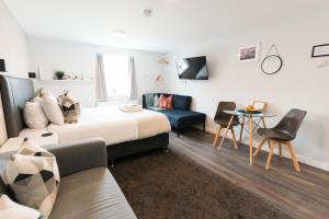 a hotel room with a bed and a couch at Prime Suites Lytham in Lytham St Annes