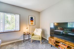 a living room with a chair and a large tv at Pet-Friendly Vacation Rental Apt Near Bishop Park! 