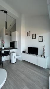 a white living room with a table and a tv at Apartment DreamVille in Crikvenica