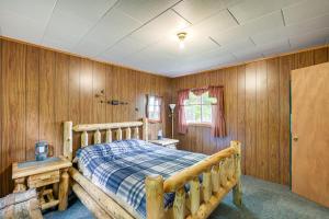 um quarto com paredes de madeira e uma cama. em Peaceful Lakefront Cabin Getaway Dock, Fire Pit! em Island Falls