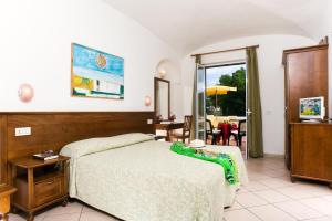 a bedroom with a bed and a view of a patio at Villa Angela Hotel & Spa in Ischia