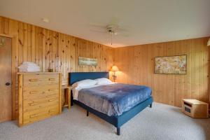 a bedroom with a bed and a wooden wall at Lakefront Osceola Vacation Rental - Dogs Welcome! in Osceola