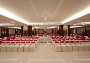 a banquet hall with red chairs in a building at The Imperial Bodhgaya in Bodh Gaya
