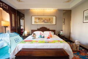 a bedroom with a bed with stuffed animals on it at Chengde Imperial Palace Hotel in Chengde