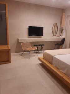 a bedroom with a bed and a flat screen tv at Sroom Apartment in Mesolongion