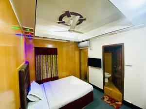 Habitación con cama y ventilador de techo. en HOTEL BLUE BIRD en Dhaka
