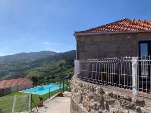 ein Haus mit einem Pool und einem Balkon in der Unterkunft Refúgio do Douro - Alojamento Local in Baião