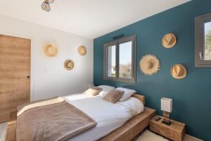 - une chambre avec un grand lit et un mur bleu dans l'établissement Le Clos du Chêne, maison avec sauna, spa et piscine, à Hadol