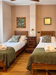 2 nebeneinander sitzende Betten in einem Schlafzimmer in der Unterkunft Convento Boutique Hotel in Susa