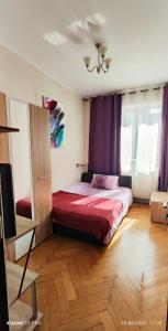 - une chambre dotée d'un lit avec des draps rouges et des rideaux violets dans l'établissement Old Town Cozy Flat, à Braşov