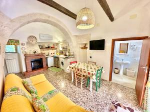 a living room with a table and a kitchen at Trulli Fenice in Martina Franca