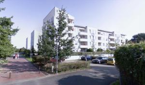 un gran edificio de apartamentos blanco con aparcamiento en O-Home Apartment with Parking, en Hannover