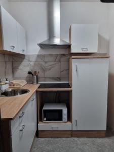 a small kitchen with a sink and a microwave at Apartment Rino in Rijeka