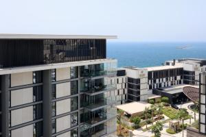 an aerial view of a tall building next to the ocean at Bluewaters Island - High-Floor 1 Bedroom Suite by Livbnb in Dubai