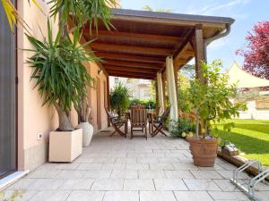 eine Terrasse mit einer hölzernen Pergola mit einem Tisch und Stühlen in der Unterkunft Portici sul giardino - Dimora dei Portici in Ortona