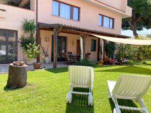 two white chairs sitting in the yard of a house at Portici sul giardino - Dimora dei Portici in Ortona