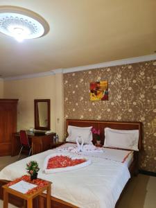 sypialnia z dużym łóżkiem z kwiatami w obiekcie Hotel Elisabeth w mieście Telaga