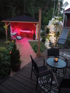 eine Terrasse mit Stühlen und einem Tisch mit rotem Licht in der Unterkunft Chata Magnata in Zamość