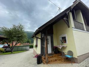 a small yellow house with a porch and two chairs at Ferienhaus Pogatschnig in Mellach
