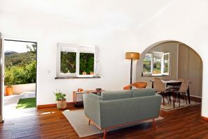 a living room with a couch and a table at Casa com pátio-São Lourenço-Ericeira in Casais de São Lourenço