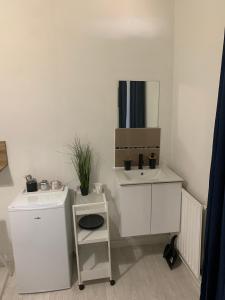 a white bathroom with a sink and a mirror at Hotel La Défense in Colombes +14 photos