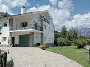 une maison blanche avec une grande allée devant elle dans l'établissement Apartamento-Casa turística l'Espígol, à Sant Llorenc de Morunys