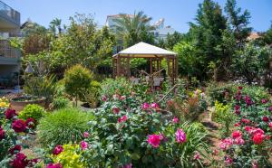 einen Garten mit Blumen und einem Pavillon in der Unterkunft Stamatakis Boutique Studios in Platanias